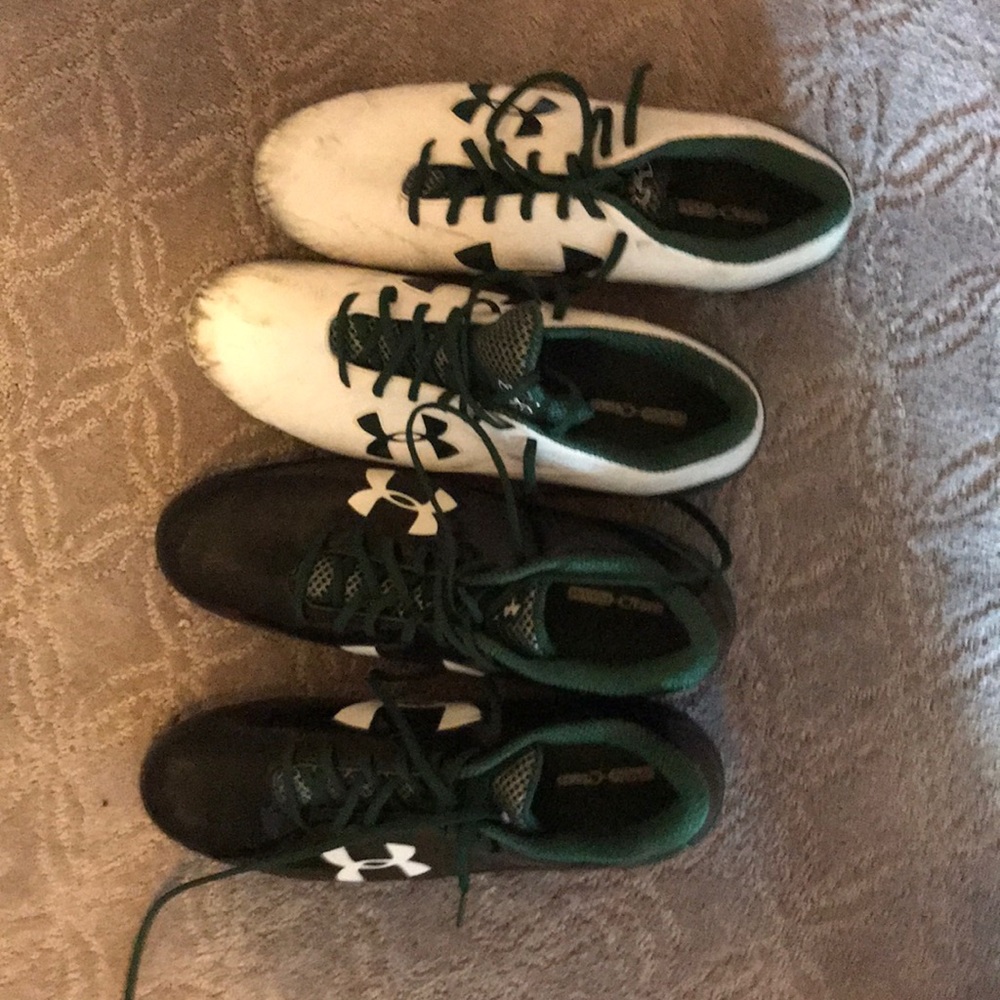 One black pair and one white pair of cleats